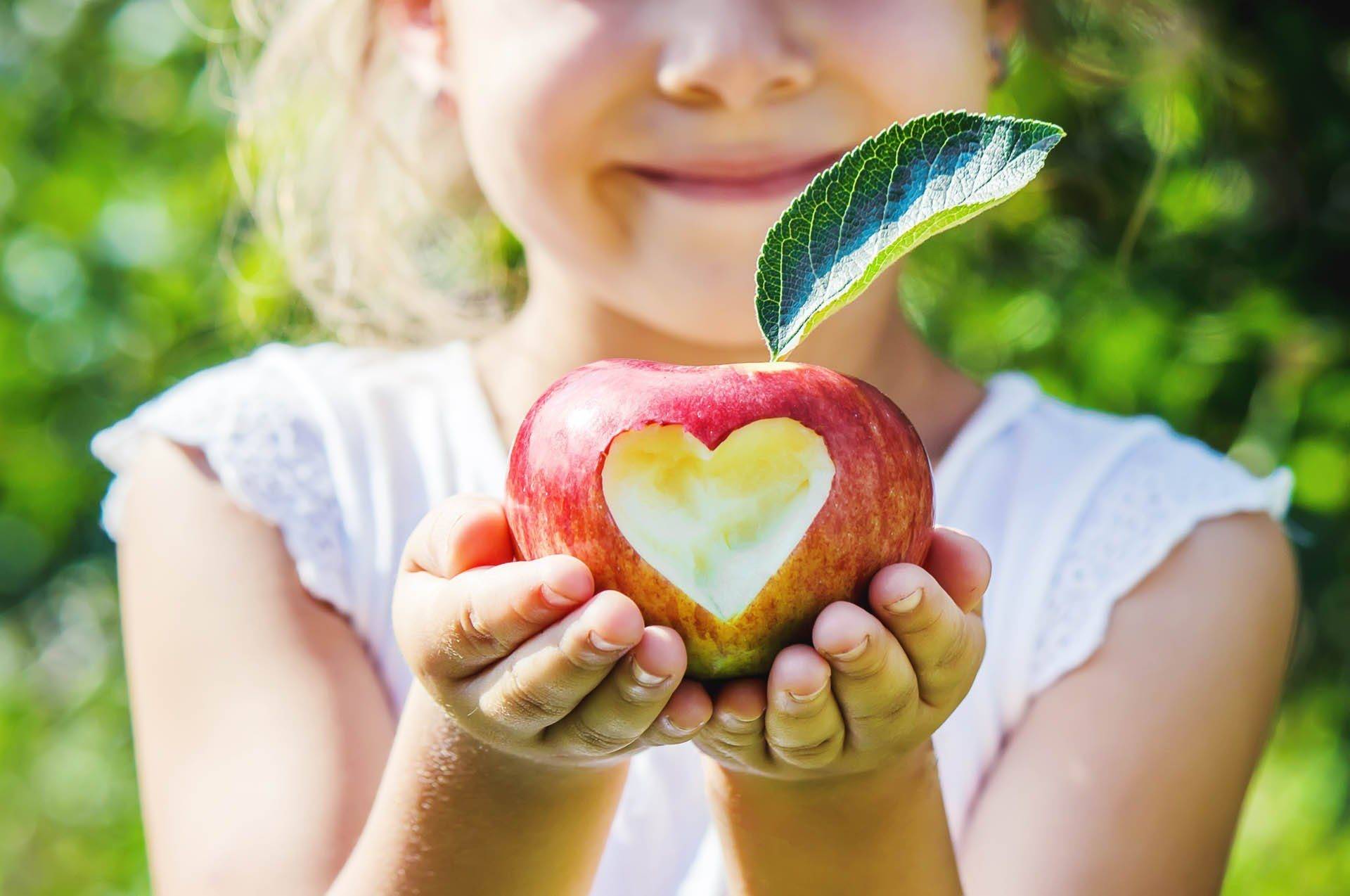 Kind mit Apfel im Garten